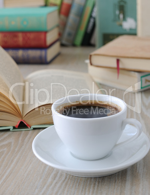 cup of coffee on a table with books.