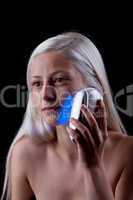 Young woman with skin problems getting phototherapy by blue ligh