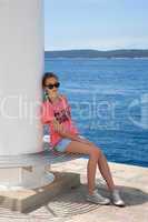 Teenage girl sitting by the sea
