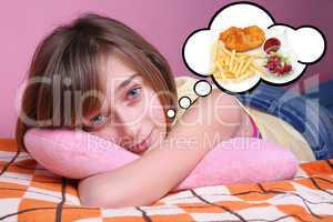 Teenage girl resting on the bed and dreaming of food