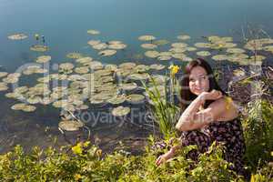Young woman by the pond
