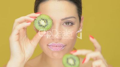 Playful woman with kiwi fruit eyes