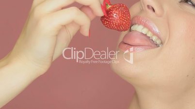Beautiful sexy woman eating a strawberry