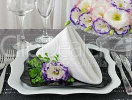 Black and white dishes served with a napkin with flowers