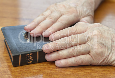 old man hands on bible