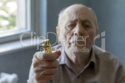 old man holding pills