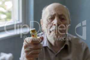 old man holding pills