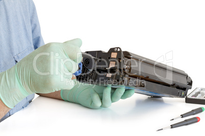 hands repairing toner cartridge