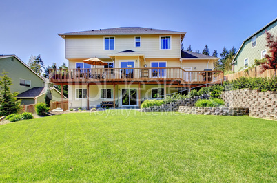 Backyard of American two story house with fenced yard.