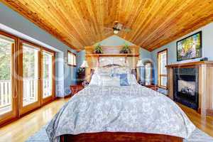Blue bedroom with wood ceiling and fireplace interior.