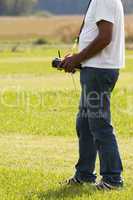 Man holding remote control for model airplane