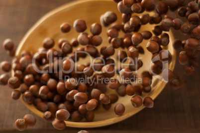 Hazelnuts in Motion Tumbling into Bamboo Bowl