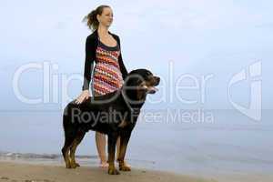 rottweiler and woman on the beach