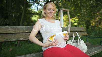 mother holding headphones on belly