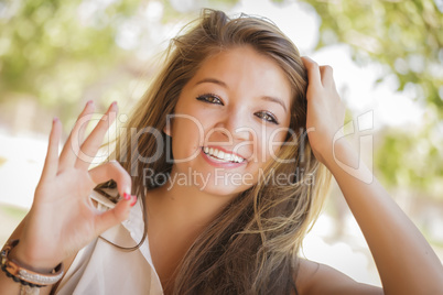 Attractive Mixed Race Girl Portrait with Okay Hand Sign Outdoors