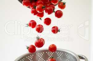 Cherry Tomatoes Tumbling Into Metal Colander