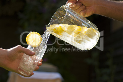 pouring homemade lemonade into glass
