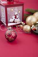 Weihnachtliche Dekoration mit Kugeln, lampe und Tanne auf rotem
