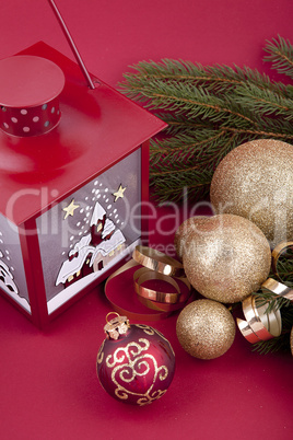 Weihnachtliche Dekoration mit Kugeln, lampe und Tanne auf rotem
