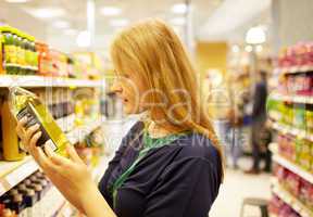 Young woman in the supermarket reading inscription