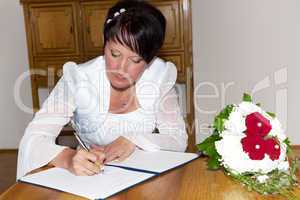 The bride signing the marriage certificate