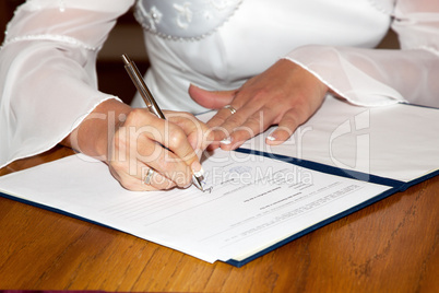 The bride signing the marriage certificate