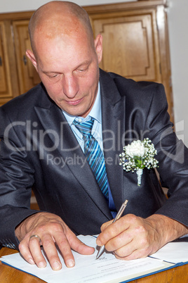 Groom sign the marriage certificate