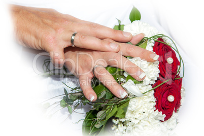 Hands with wedding rings and bridal bouquet