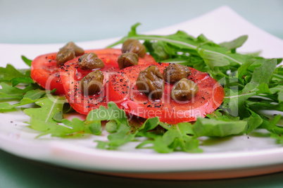 Salad with fresh tomatoes, capers and arugula