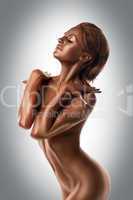 nude woman with metal skin posing like statue