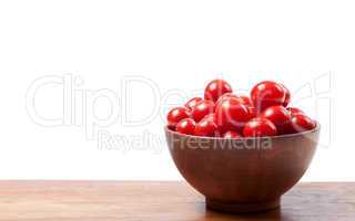 Cherry tomato in ceramic bowl on wooden kitchen table