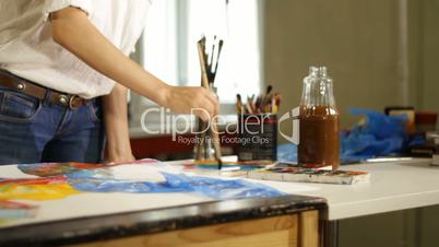 Woman artist painting watercolor paints