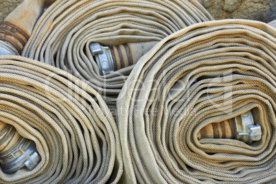 Old rolled fire hoses with nozzles