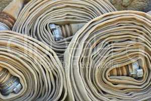 Old rolled fire hoses with nozzles