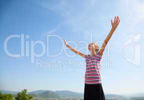 Teenage girl staying with raised hands