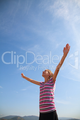 Teenage girl staying with raised hands