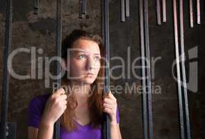 Young woman behind the bars