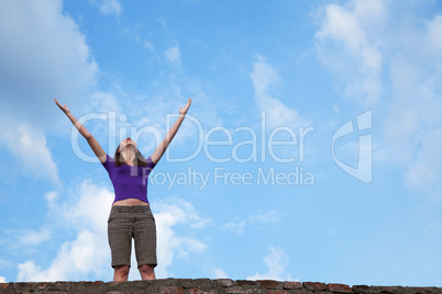 Young woman staying with raised hands