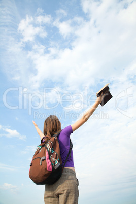 Teenage girl staying with raised hands