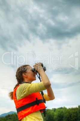 Young woman looking through binoculars