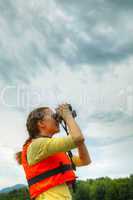 Young woman looking through binoculars