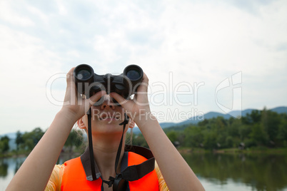 Young woman looking through binoculars