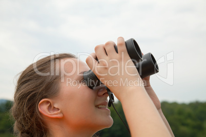 Young woman looking through binoculars