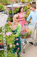 Garden center worker pushing flower shelves