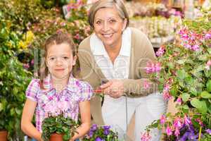 Senior woman and girl in garden center