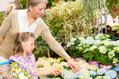 Garden center girl with grandmother buy flowers