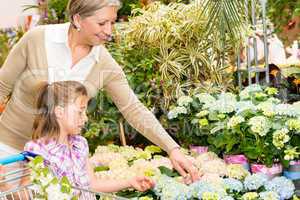 Garden center girl with grandmother buy flowers