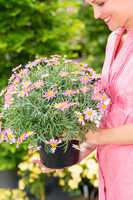 Woman hold potted daisy flower garden centre