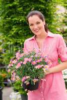 Smiling woman hold pink potted flower