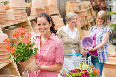 Garden centre woman hold red potted geranium